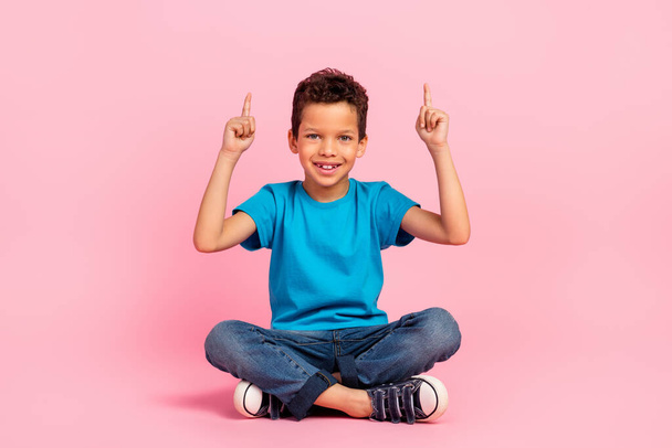 Full length photo of sweet excited little boy dressed blue t-shirt showing two fingers up empty space isolated pink color background. - Photo, image