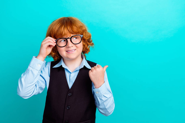 Portrait of small positive schoolchild hand touch eyewear look indicate finger empty space isolated on turquoise color background. - Fotoğraf, Görsel