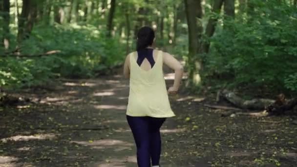 Estilo de vida activo en las naturalezas Abrace: Girl Engaging in Refreshing Park Jog. Imágenes de alta calidad 4k - Metraje, vídeo