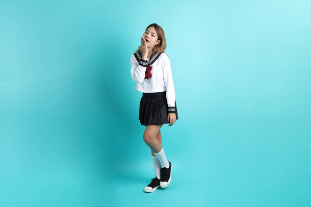The Asian girl in Japanese student uniform standing on the green background. - Photo, Image