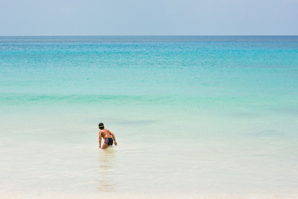 Молодий хлопець стоїть на березі океану
 - Фото, зображення