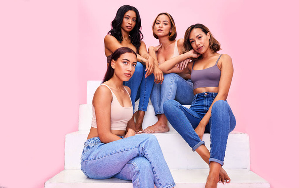 Fashion, stairs and portrait of women on pink background for clothing promotion, discount and retail sale. Friends, beauty and happy people in studio in denim outfit, trendy clothes and casual style. - Φωτογραφία, εικόνα