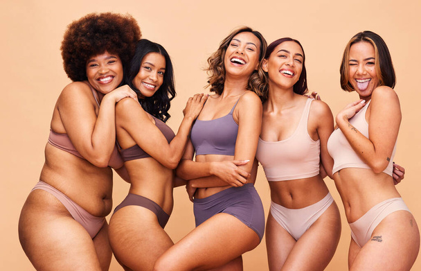 Body positive, self love and portrait of women in studio in underwear for wellness, beauty and diversity. Lingerie campaign, natural and people on brown background for pride, skincare and inclusion. - Photo, Image