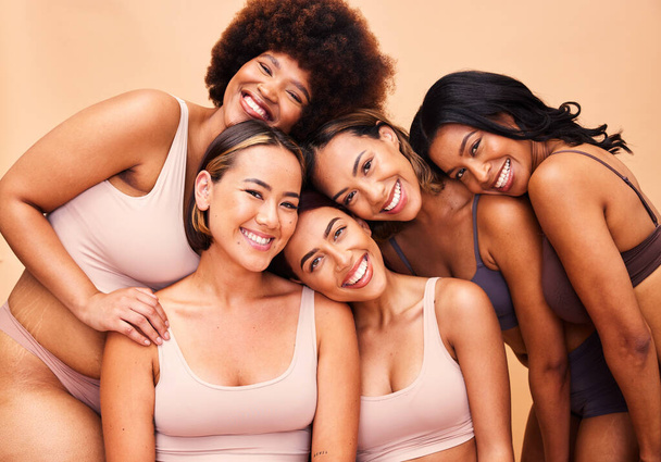 Portrait, diversity and women with beauty, wellness and body positivity on a beige studio background. Models, friends or group with self love, inclusion and support with skincare, aesthetic and smile. - 写真・画像