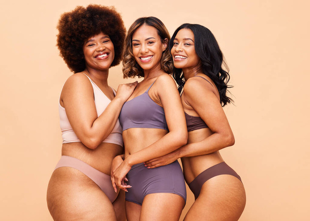 Diversity, body positivity and portrait of women with smile, self love and solidarity in studio together. Happiness, group of people on beige background with underwear, skincare and cosmetic equality. - 写真・画像
