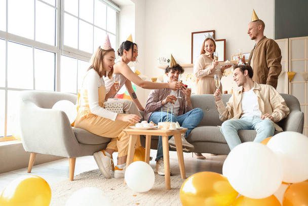 Grupo de jóvenes amigos con champán celebrando el cumpleaños en casa - Foto, Imagen