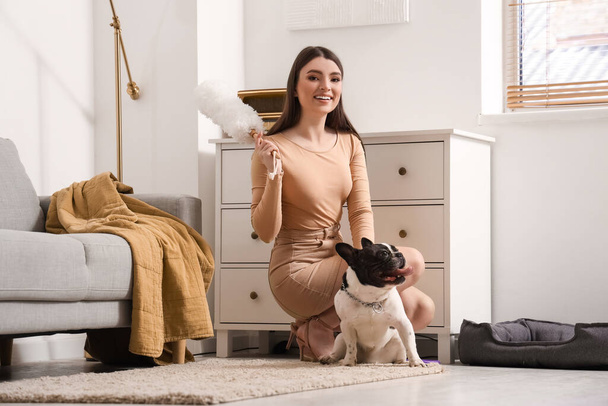 Mujer joven con pp-duster y su bulldog francés en casa - Foto, imagen