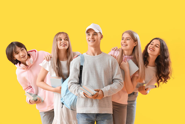 Group of students with books on yellow background - Photo, Image