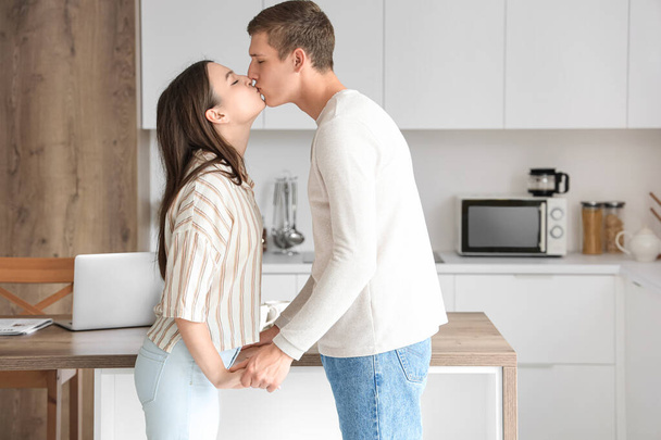 幸せな若いカップルが台所でキス - 写真・画像