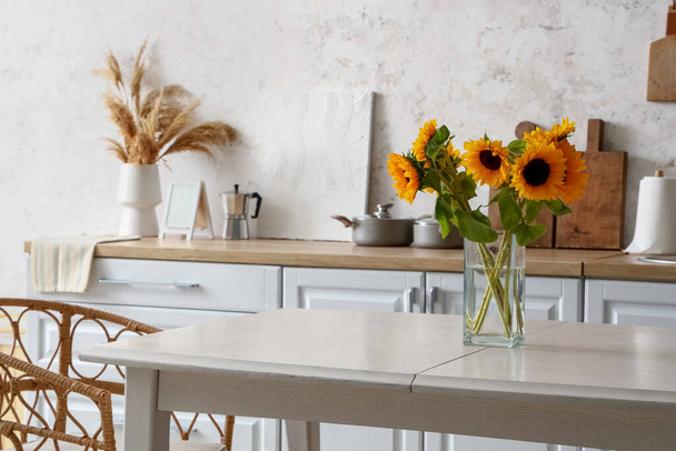 Vase with sunflowers on dining table in modern kitchen - Photo, Image