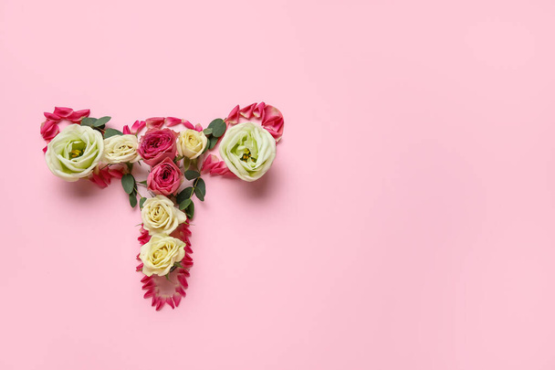 Uterus made of beautiful flowers on pink background - Photo, Image