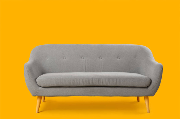 Kodikas harmaa sohva keltaisella pohjalla - Valokuva, kuva