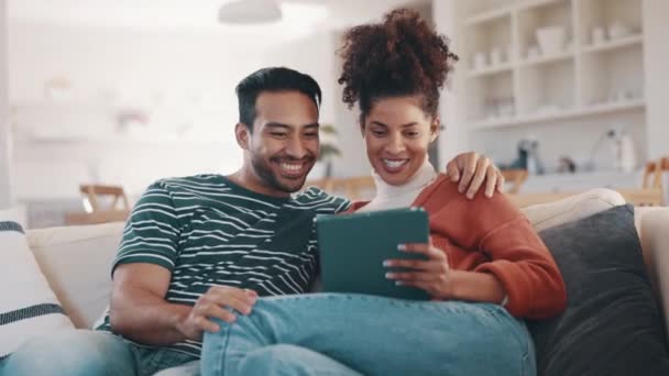 Happy couple on sofa with tablet, laughing at social media meme or funny internet video in home together. Relax, man and woman on couch browse, checking online post or joke on website on digital app - Footage, Video