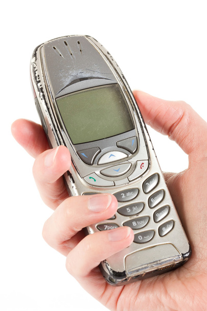Vanha kuluneet matkapuhelin pidetään yli valkoinen
 - Valokuva, kuva
