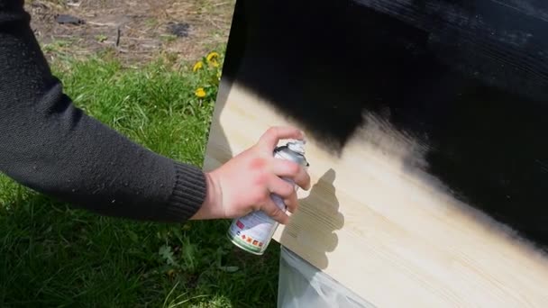 Férfi kézi festés fa fekete spray festék. Munkás alkalmazó lakk festék fa asztal felületén, festés és gondozás a fa. Ház felújítás, fénymásolás, textúra. - Felvétel, videó