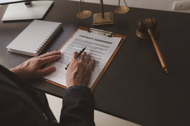 Lawyer sits in office with litigation contract documents, attorneys draft contracts and legal terms for clients for litigation, fair and transparent litigation. Lawyer concept and litigation. - Photo, Image
