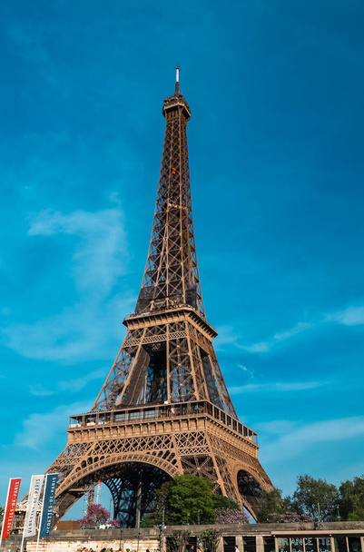 Παρίσι, Γαλλία. 22 Απριλίου 2022: Τοπίο με θέα τον Πύργο του Άιφελ και τον όμορφο γαλάζιο καλοκαιρινό ουρανό. - Φωτογραφία, εικόνα