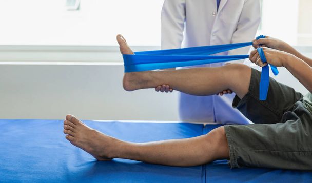 : 理学療法士の医師は,患者の膝と脚の治療を監視するために働き,彼は痛みを決定するために患者の膝にハンドルを使用します. ケガセラピスト - 写真・画像