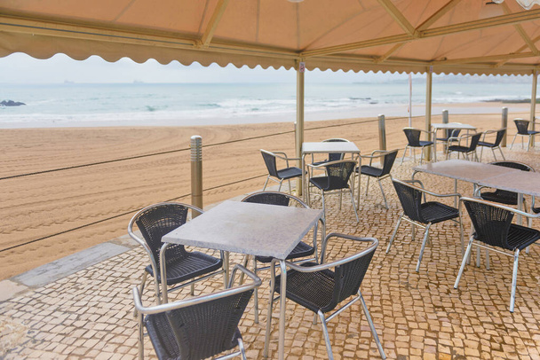 tafels met stoelen op het strand - Foto, afbeelding