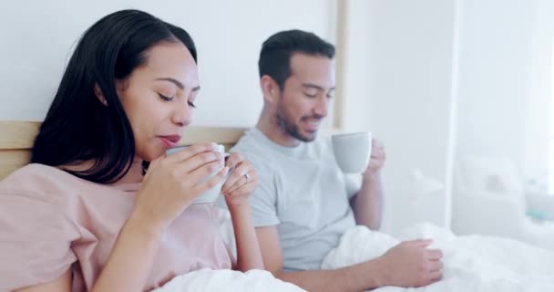 愛,朝,夫婦が一緒に寝室で紅茶を飲みながら,家で週末にリラックスする. ロマンスのための彼らのアパートでベッドで話している男と女性とコーヒー,笑顔または幸せ. - 映像、動画
