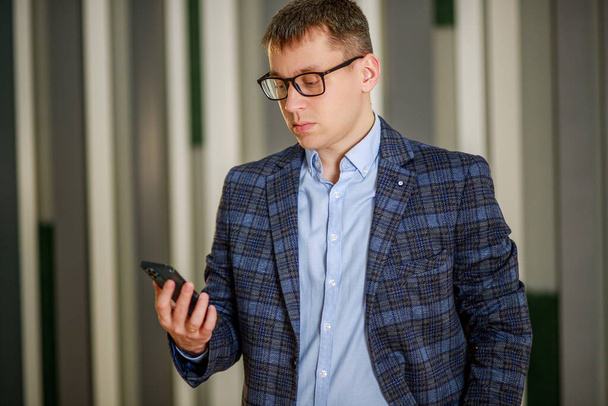 Homme d'affaires tapant un message texte sur un smartphone, travail en ligne, bureau - gestionnaire. - Photo, image