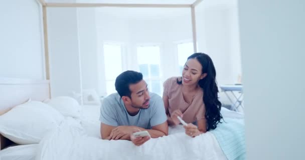 Happy couple, bed and pregnancy test in good news, positive or celebration in happiness, family or home. Excited man and woman smile lying in bedroom in maternity, parents or growth together in house. - Footage, Video