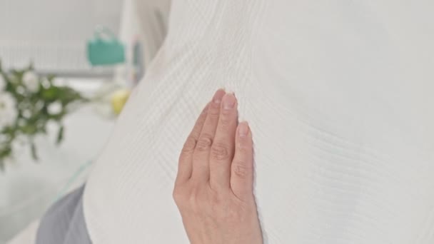 Vertikální záběr ruky nerozpoznatelné pacientky ležící na nemocničním lůžku ve spánku - Záběry, video