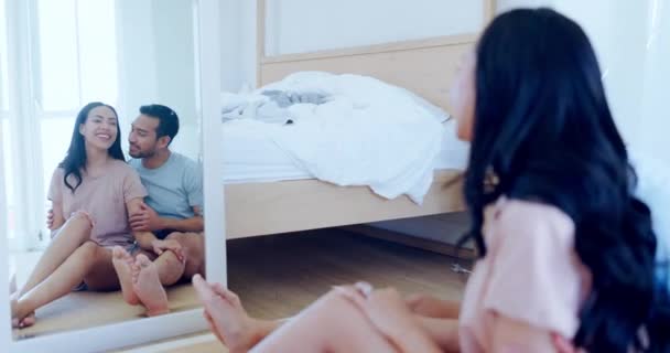 Mirror, bedroom and couple on floor in morning for relaxing, talking and bonding at home. Reflection, dating and happy man and woman laugh, embrace and speak for healthy relationship in apartment. - Footage, Video