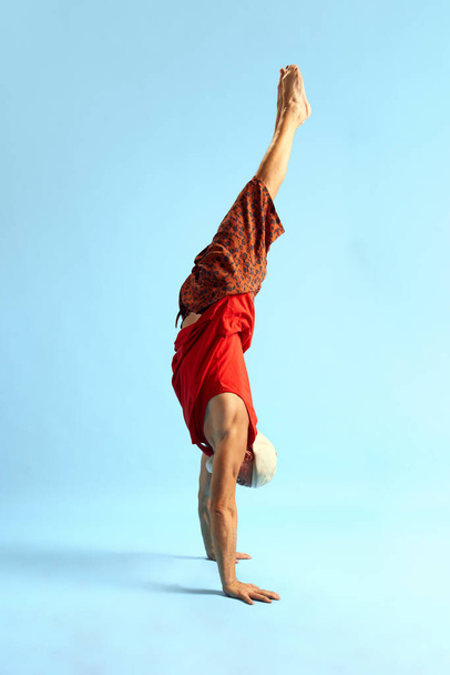 Rosca deportiva vida. Balance. Meditando. Recreación. Imagen vertical de cuerpo entero del hombre de pie sobre sus manos. Vista lateral. El concepto de cuidado corporal, estilo de vida saludable, fuerza, musculatura. - Foto, imagen