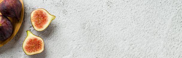 Вид цілих і порізаних органічних інжирів на кам'яному столі - Фото, зображення