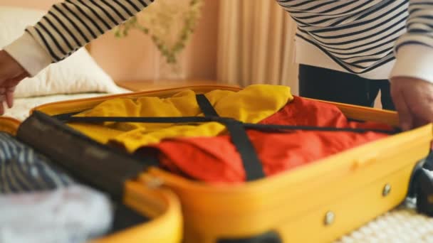 Close-up van vrouwelijke handen inpakken en vergrendelen tas voor vakantie reis. Latino vrouw bereidt een reiskoffer voor. Hoge kwaliteit FullHD beeldmateriaal - Video