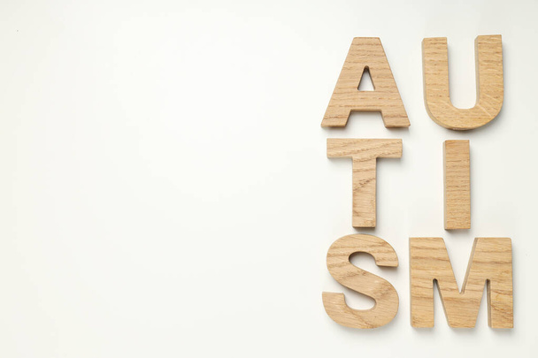 La palabra "autismo" en letras de madera sobre un fondo claro, lugar para el texto. Concepto del Día Mundial del autismo - Foto, imagen