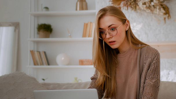 Καυκάσια σοκαρισμένη γυναίκα με γυαλιά κοιτάζοντας φορητό υπολογιστή ανάγνωση κακά νέα κοντά το στόμα με τα χέρια κρατώντας το κεφάλι με σοκ αποτυχία φοιτητής κορίτσι χαθεί με υπολογιστή επιχειρηματίας ανησυχούν για το επιχειρηματικό πρόβλημα - Φωτογραφία, εικόνα