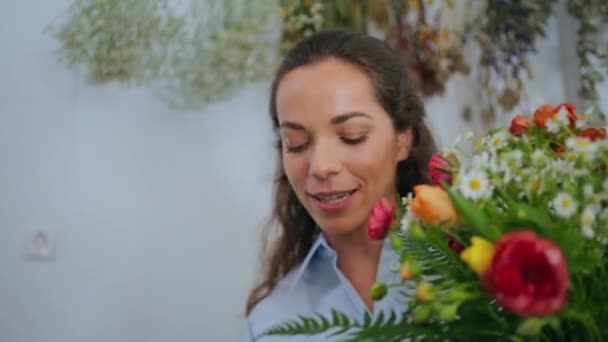 Bloemisten werknemer houden boeket bloemen arrangement in mooie bloemenwinkel. Close-up aantrekkelijke ondernemer genieten van bloemrozen samenstelling in decoratie ambachtelijke winkel. Natuurschoonheidsconcept. - Video