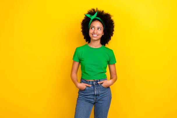 Photo of minded adorable girl beaming smile look empty space wear cropped top isolated on yellow color background. - Photo, image