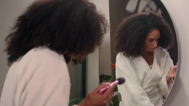 Krásná afro americká žena pozdě na randění dívka v županu doma zrcadlo odraz použít prášek pro obličej make up kosmetika odpověď call naštvaný šílený křik v mobilním telefonu konflikt hádka křik - Záběry, video