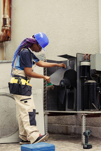 Pulizia tecnica certificata afroamericana costruita strato di sporco e polvere dalle parti interne del condizionatore d'aria per prevenire la riduzione della capacità di raffreddamento e della capacità di lavoro - Foto, immagini