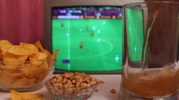 Kijken naar de voetbalwedstrijd op televisie bij lokale pub. Voedsel, bier. - Video