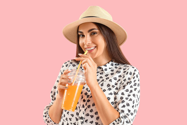 Junge Frau trinkt Saft auf rosa Hintergrund - Foto, Bild