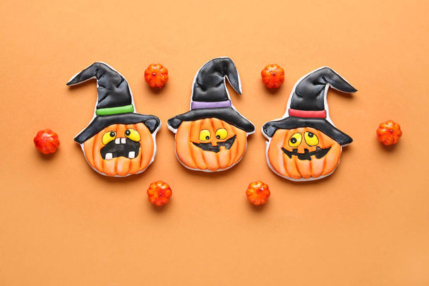 Composition with tasty cookies and pumpkins for Halloween celebration on beige background - Photo, Image
