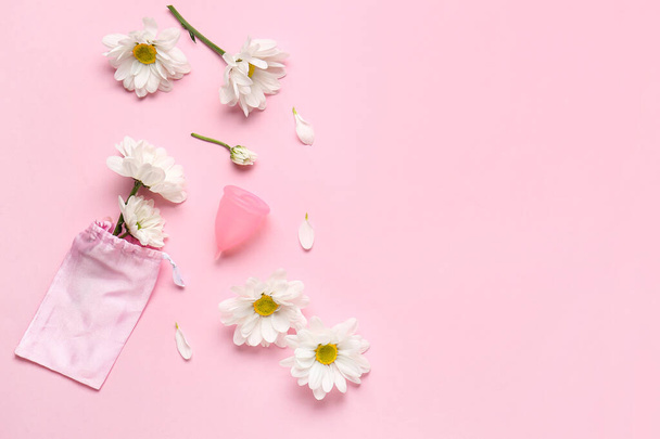 Composition with menstrual cup and beautiful chamomile flowers on pink background - Photo, Image