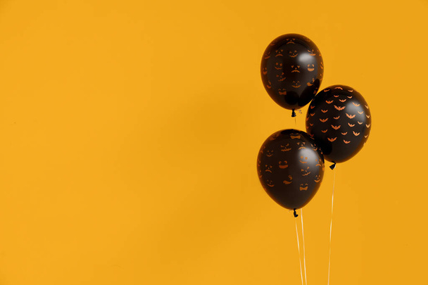Diferentes globos de Halloween negros sobre fondo naranja - Foto, Imagen