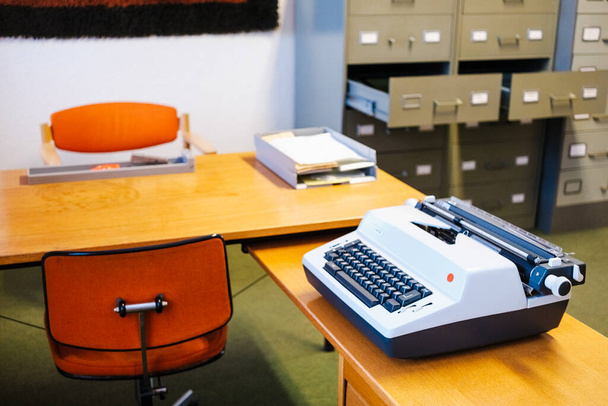 Винтажная офисная мебель в стиле 70-х годов с электрической пишущей машинкой. - Фото, изображение