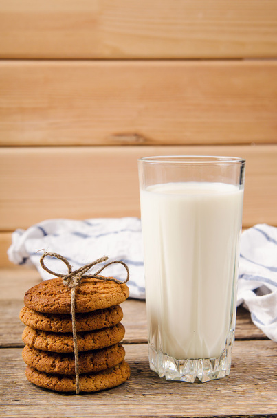rustic oatmeal cookies on wooden table with a glass of milk - Photo, image