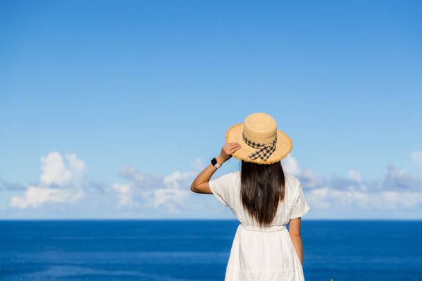 Τουριστική γυναίκα απολαμβάνουν τη θέα στη θάλασσα στην ηλιόλουστη μέρα - Φωτογραφία, εικόνα