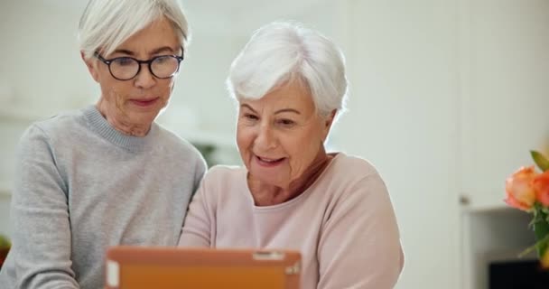 Tablet, app and senior woman friends browsing the internet while in their home for retirement. Technology, smile and surprise with elderly people using social media for good news or information. - Séquence, vidéo