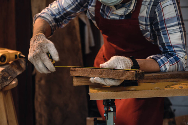 Carpinteiro use fita métrica e lápis para marcação em madeira. Foco seletivo e close-up à mão para trabalhar. - Foto, Imagem