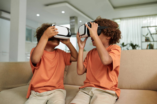 Irmãos jogando jogo em óculos de realidade virtual em casa - Foto, Imagem