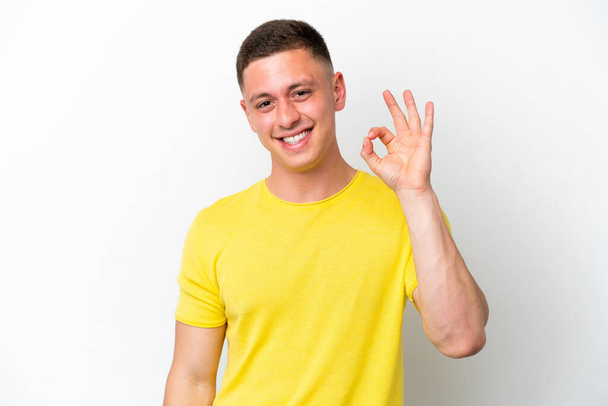 Jovem brasileiro isolado em fundo branco mostrando sinal ok com os dedos - Foto, Imagem