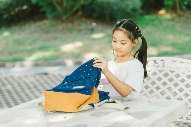 Χαριτωμένο κορίτσι ασιατικό παιδί παίζει με τα ρούχα στον υπαίθριο κήπο. - Φωτογραφία, εικόνα